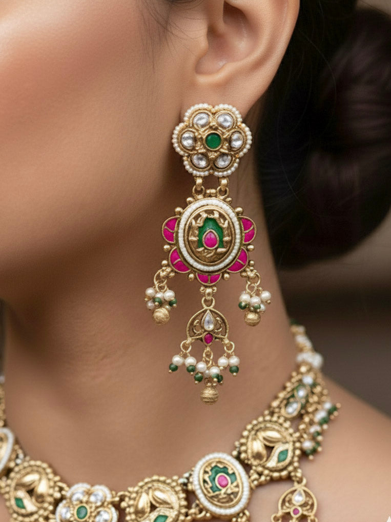 Close-up of a woman wearing an ornate traditional Mint Green Heritage gold Collar jewellery set and earrings with Pearls and Colored Stone. Saree styling inspiration with a traditional heritage necklace. Close-up of intricate antique finishing in heritage imitation jewelry.