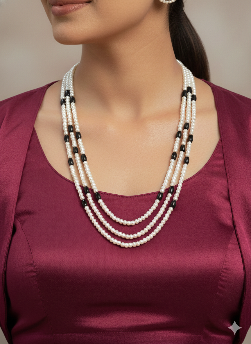 Close-up of a woman wearing an ornate Indo-Western White and Black Layered Jewellery Set and Earrings with Pearls and BLack Colored Beads. Indo-western outfit styled with an artifical Pearl Necklace Set. 