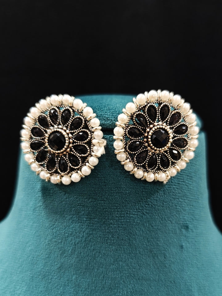 Close-up of an ornate Indo-Western White and Black Layered Jewellery Set and Earrings with Pearls and BLack Colored Beads. Indo-western outfit styled with an artifical Pearl Necklace Set. 