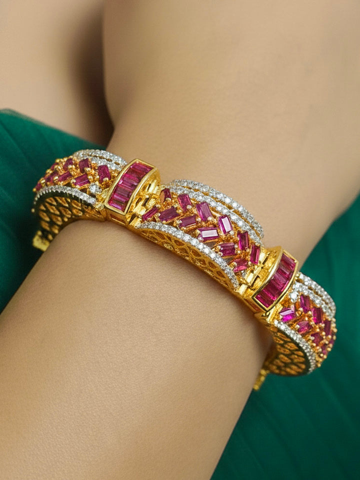 Close-up of a woman wearing an ornate Indo-western American Diamond Pink Bracelet with Gold Polish, Pink Colored Stones, American Diamond and filigree Work. Reception-ready look featuring a statement American diamond Bracelet. Close-up of a cocktail party look featuring a premium American diamond Bracelet.