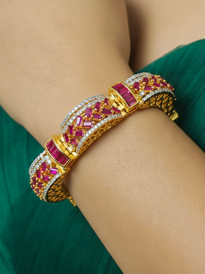 Close-up of a woman wearing an ornate Indo-western American Diamond Pink Bracelet with Gold Polish, Pink Colored Stones, American Diamond and filigree Work. Reception-ready look featuring a statement American diamond Bracelet. Close-up of a cocktail party look featuring a premium American diamond Bracelet.