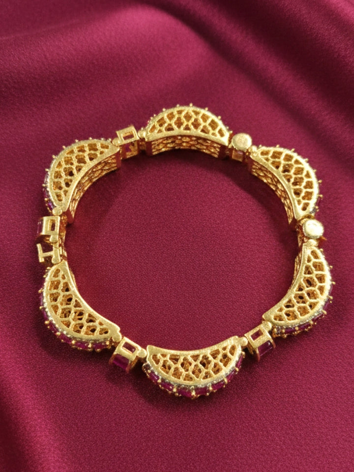 Close-up of an ornate Indo-western American Diamond Pink Bracelet with Gold Polish, Pink Colored Stones, American Diamond and filigree Work. Reception-ready look featuring a statement American diamond Bracelet. Close-up of a cocktail party look featuring a premium American diamond Bracelet.