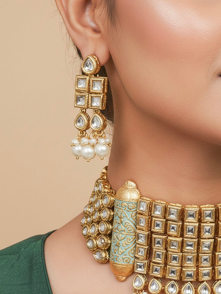 Close-up of a woman wearing an ornate traditional Meenakari gold Choker jewellery set and earrings with Kundan, Meenakari and Pearls. Reception party styling featuring a premium Meenakari imitation set. Close-up of detailed enamel craftsmanship in Meenakari jewelry.