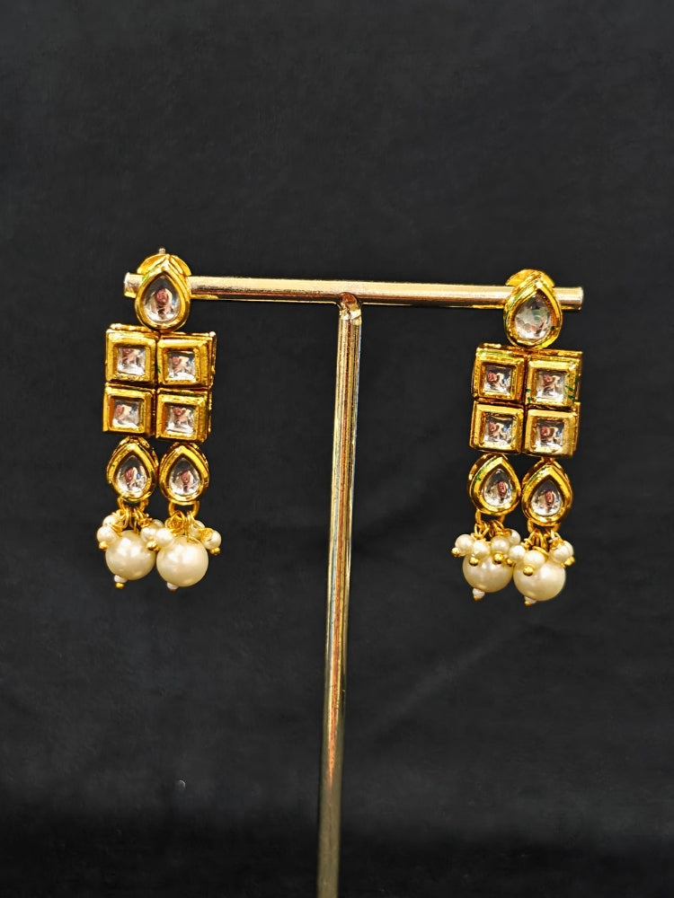 Close-up of an ornate traditional Meenakari gold Choker jewellery set and earrings with Kundan, Meenakari and Pearls. Reception party styling featuring a premium Meenakari imitation set. Close-up of detailed enamel craftsmanship in Meenakari jewelry.