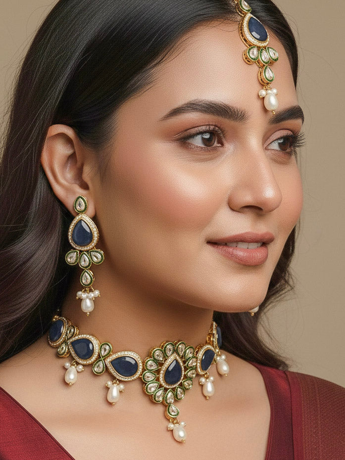 Close-up of a women wearing an ornate traditional Navy Blue Choker jewellery set and earrings and maangtikka with Kundan, Monalisa Stone, American Diamonds, Beads and Reverse American Diamonds and tumble stones. A graceful woman wearing a trending Colored Stone necklace for a 2026 wedding celebration. Elegant wedding jewelry look featuring a premium artificial Colored Stone necklace.