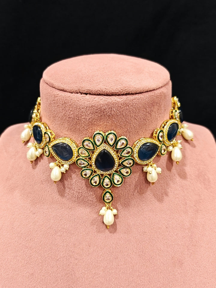 Close-up of an ornate traditional Navy Blue Choker jewellery set and earrings and maangtikka with Kundan, Monalisa Stone, American Diamonds, Beads and Reverse American Diamonds and tumble stones. A graceful woman wearing a trending Colored Stone necklace for a 2026 wedding celebration. Elegant wedding jewelry look featuring a premium artificial Colored Stone necklace.