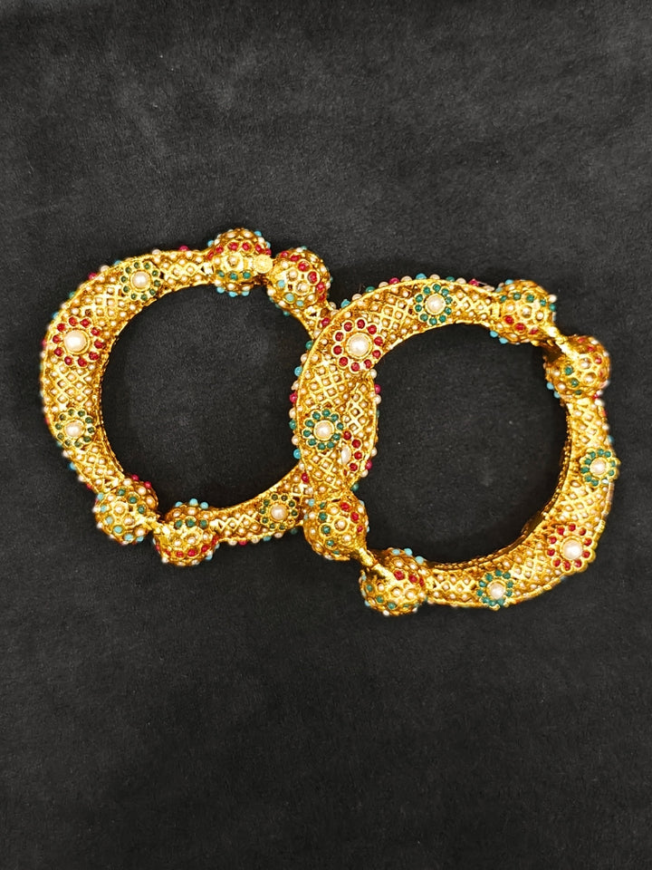 Close-up of an ornate traditional (Gold Polish) Bracelet with Colored Stones. Mehendi ceremony look completed with a Colored stone Bracelet. 