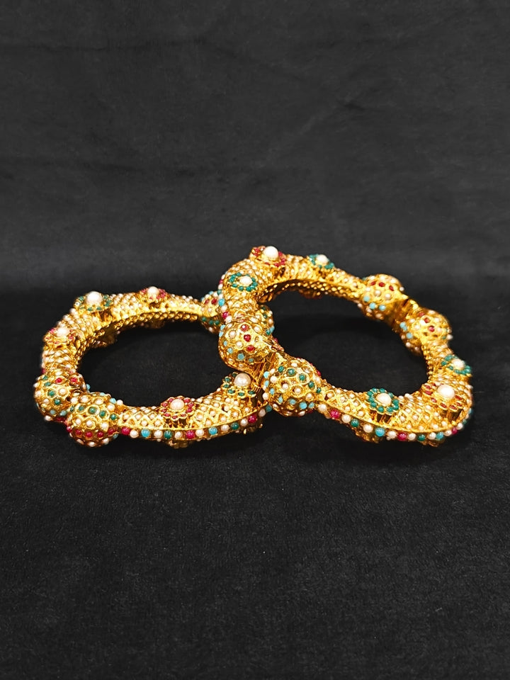 Close-up of an ornate traditional (Gold Polish) Bracelet with Colored Stones. Mehendi ceremony look completed with a Colored stone Bracelet. 