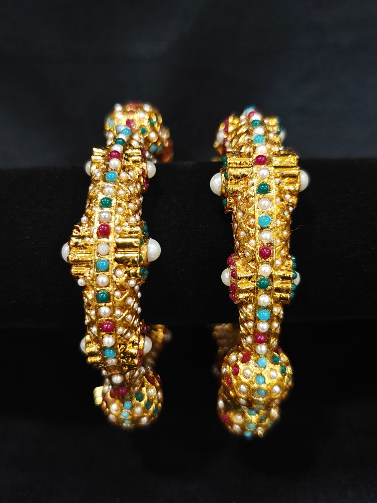 Close-up of an ornate traditional (Gold Polish) Bracelet with Colored Stones. Mehendi ceremony look completed with a Colored stone Bracelet. 