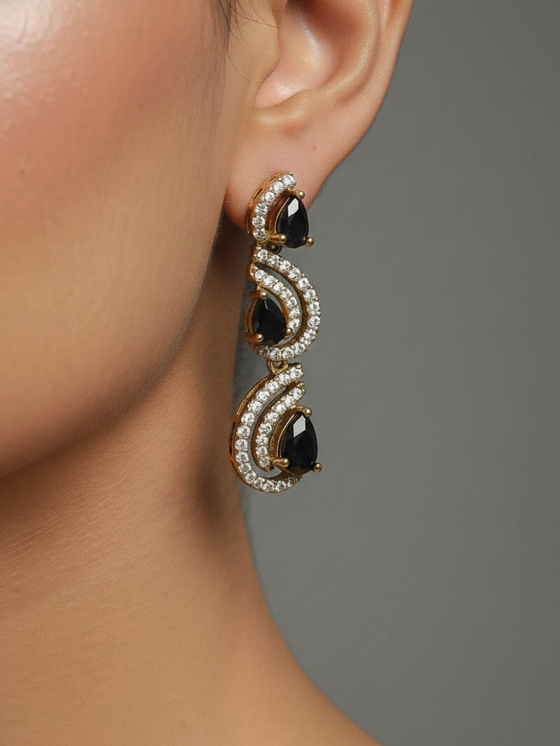 Close-up of a woman wearing an ornate Indo-Western Black Diamond gold Collar jewellery set and earrings with American Diamond and Black Colored Stones. Close-up of a cocktail party look featuring a premium American diamond necklace. Mehendi function outfit styled with a lightweight American Diamond necklace.