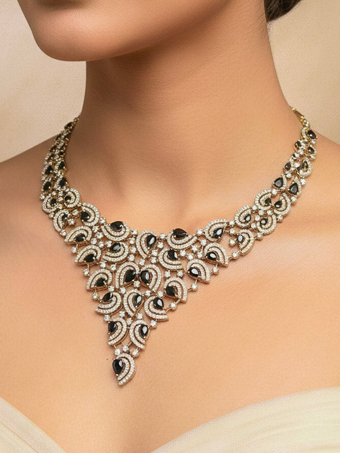 Close-up of a woman wearing an ornate Indo-Western Black Diamond gold Collar jewellery set and earrings with American Diamond and Black Colored Stones. Close-up of a cocktail party look featuring a premium American diamond necklace. Mehendi function outfit styled with a lightweight American Diamond necklace.