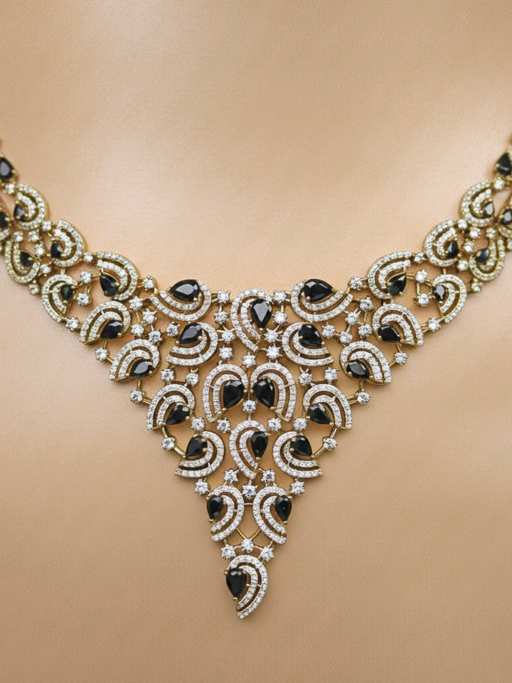 Close-up of a woman wearing an ornate Indo-Western Black Diamond gold Collar jewellery set and earrings with American Diamond and Black Colored Stones. Close-up of a cocktail party look featuring a premium American diamond necklace. Mehendi function outfit styled with a lightweight American Diamond necklace.