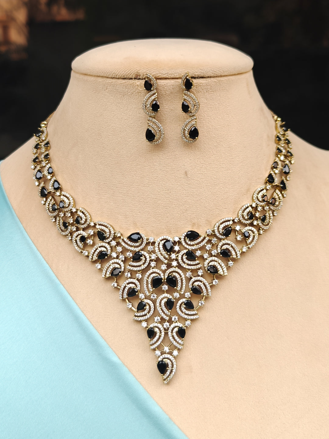 "A stunning glamorous artificial diamond necklace with black colored stone paired with chic earrings, perfect for bridal wear. This high-quality artificial diamond jewelry set is the ideal choice for modern brides looking for a budget-friendly option with timeless sparkle."