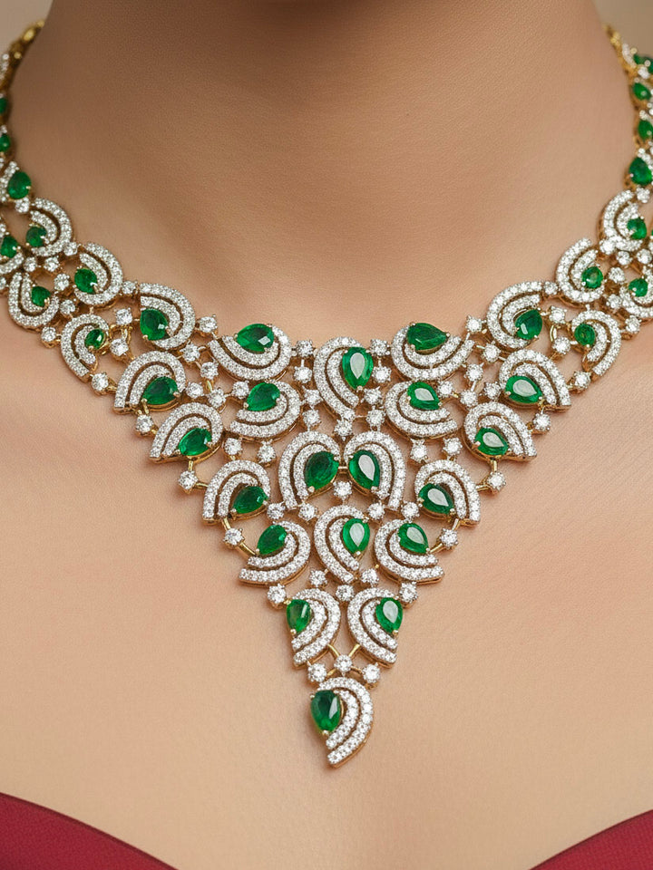 Close-up of a woman wearing an ornate Indo-Western Green Diamond gold Collar jewellery set and earrings with American Diamond and Green Colored Stones. Close-up of a cocktail party look featuring a premium American diamond necklace. Mehendi function outfit styled with a lightweight American Diamond necklace.