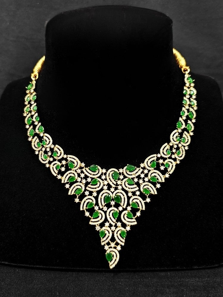Close-up of a woman wearing an ornate Indo-Western Green Diamond gold Collar jewellery set and earrings with American Diamond and Green Colored Stones. Close-up of a cocktail party look featuring a premium American diamond necklace. Mehendi function outfit styled with a lightweight American Diamond necklace.