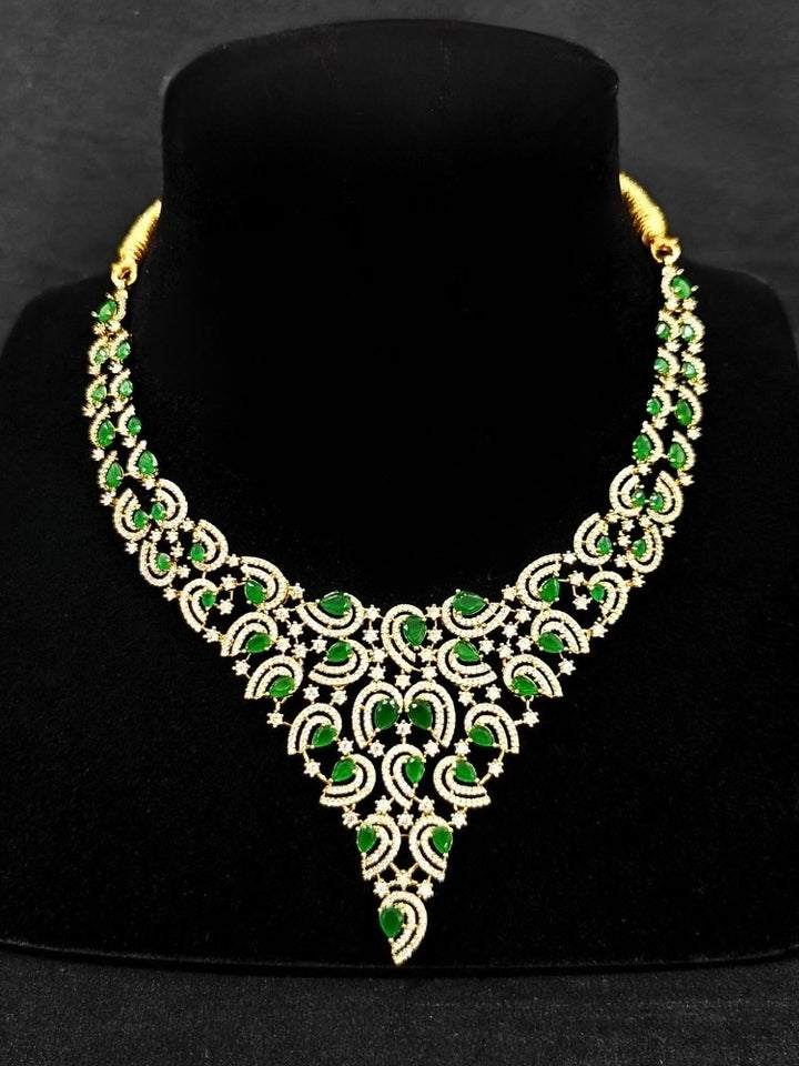Close-up of a woman wearing an ornate Indo-Western Green Diamond gold Collar jewellery set and earrings with American Diamond and Green Colored Stones. Close-up of a cocktail party look featuring a premium American diamond necklace. Mehendi function outfit styled with a lightweight American Diamond necklace.