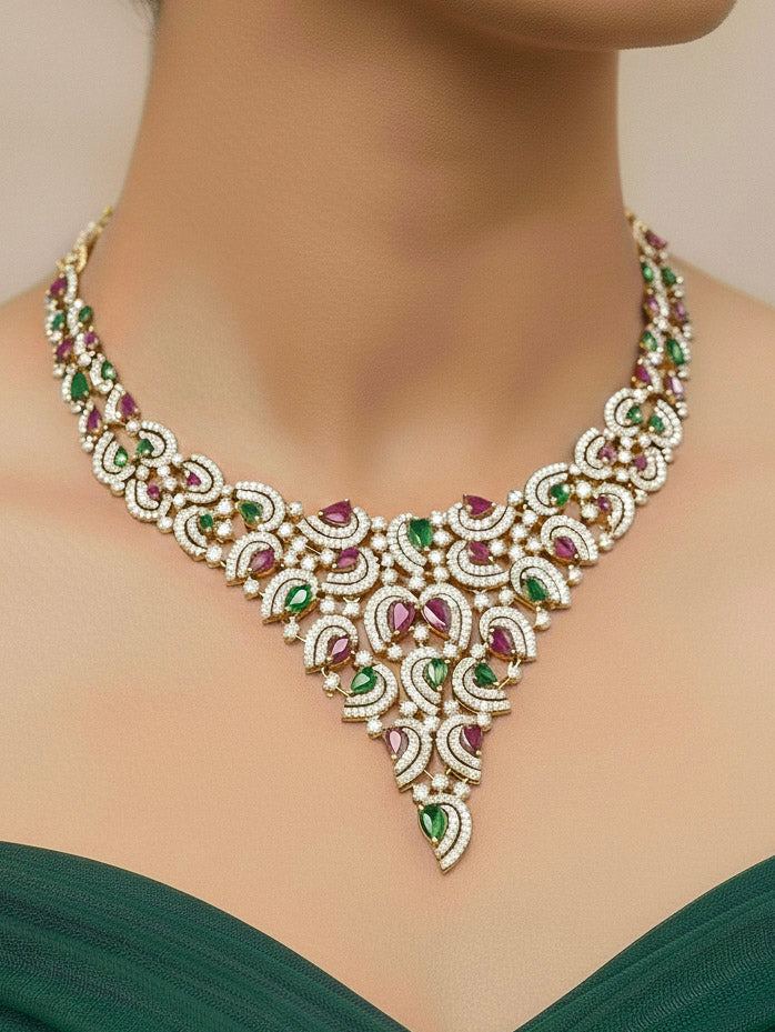 Close-up of a woman wearing an ornate Indo-Western Ruby Pink & Green Diamond gold Collar jewellery set and earrings with American Diamond and Ruby Pink & Green Colored Stones. Close-up of a cocktail party look featuring a premium American diamond necklace. Mehendi function outfit styled with a lightweight American Diamond necklace.