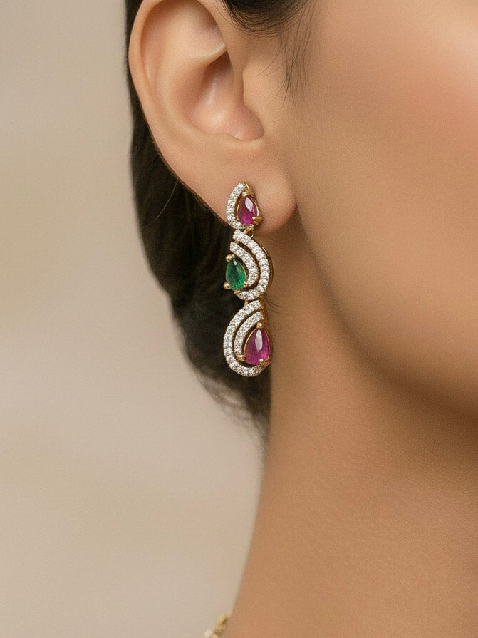 Close-up of a woman wearing an ornate Indo-Western Ruby Pink & Green Diamond gold Collar jewellery set and earrings with American Diamond and Ruby Pink & Green Colored Stones. Close-up of a cocktail party look featuring a premium American diamond necklace. Mehendi function outfit styled with a lightweight American Diamond necklace.
