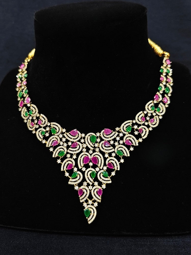 Close-up of an ornate Indo-Western Ruby Pink & Green Diamond gold Collar jewellery set and earrings with American Diamond and Ruby Pink & Green Colored Stones. Close-up of a cocktail party look featuring a premium American diamond necklace. Mehendi function outfit styled with a lightweight American Diamond necklace.