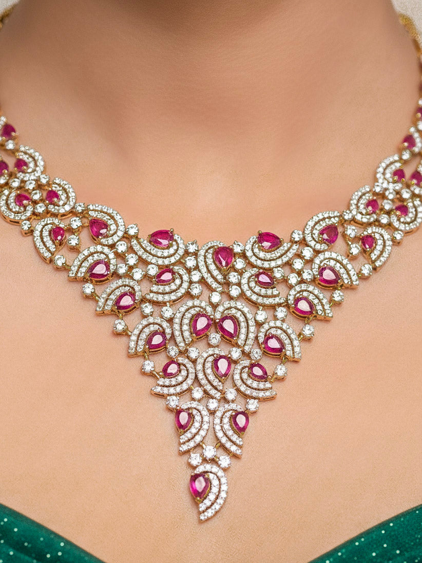 Close-up of a woman wearing an ornate Indo-Western Red Diamond gold Collar jewellery set and earrings with American Diamond and Red Colored Stones. Close-up of a cocktail party look featuring a premium American diamond necklace. Mehendi function outfit styled with a lightweight American Diamond necklace.