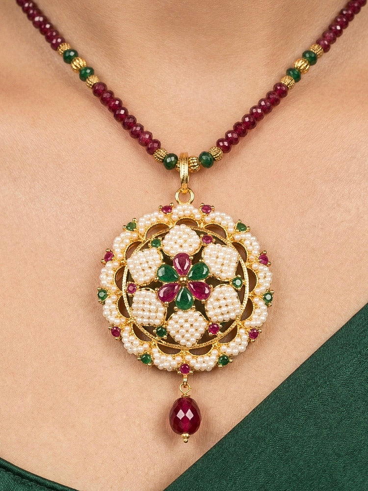 Close-up of a woman wearing an ornate traditional Pearl Pendant Set  earrings with Pearl and Colored Stones. Festive celebration look enhanced with traditional Pearl jewelry. Close-up of detailed enamel craftsmanship in Pearl jewelry.