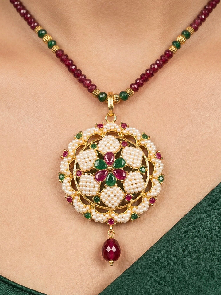 Close-up of a woman wearing an ornate traditional Pearl Pendant Set  earrings with Pearl and Colored Stones. Festive celebration look enhanced with traditional Pearl jewelry. Close-up of detailed enamel craftsmanship in Pearl jewelry.