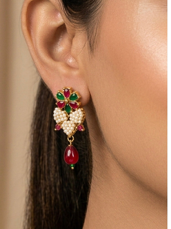 Close-up of a woman wearing an ornate traditional Pearl Pendant Set  earrings with Pearl and Colored Stones. Festive celebration look enhanced with traditional Pearl jewelry. Close-up of detailed enamel craftsmanship in Pearl jewelry.