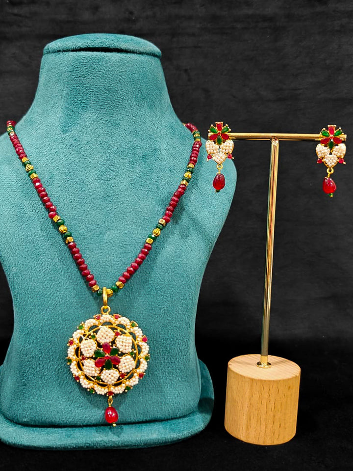 Close-up of an ornate traditional Pearl Pendant Set  earrings with Pearl and Colored Stones. Festive celebration look enhanced with traditional Pearl jewelry. Close-up of detailed enamel craftsmanship in Pearl jewelry.