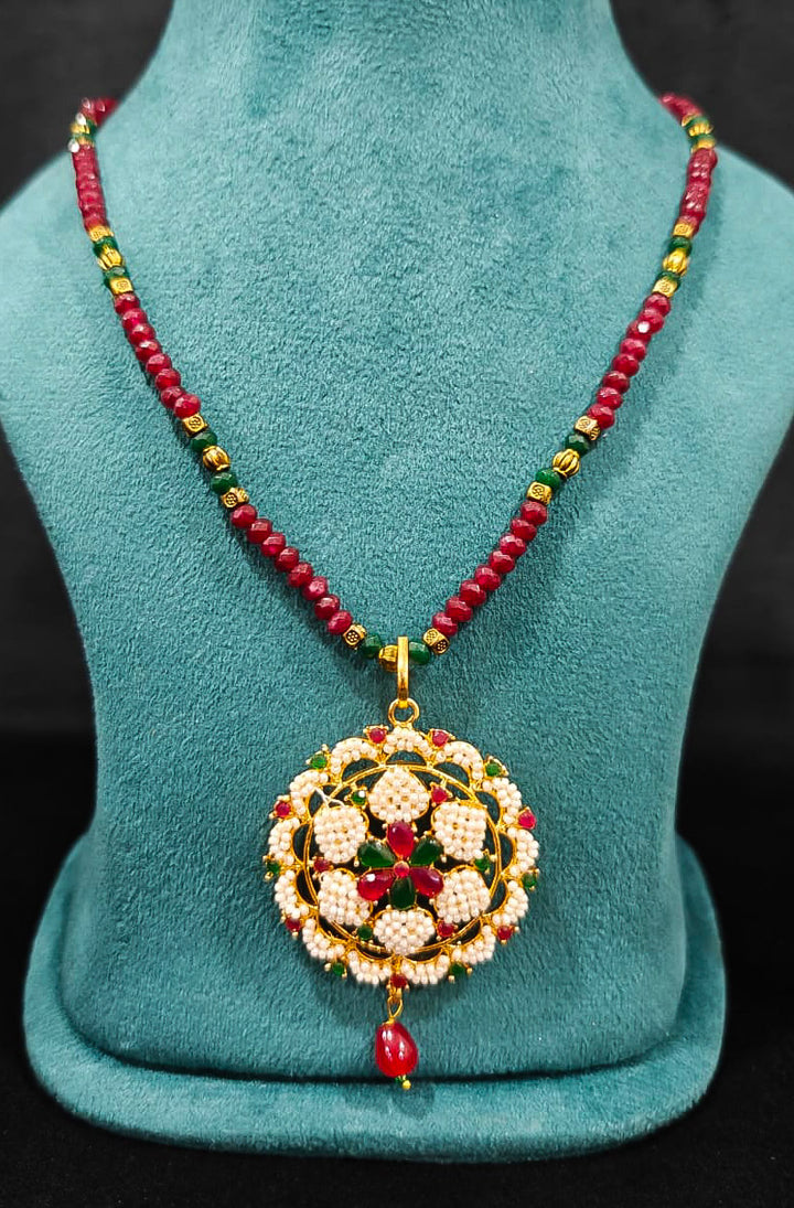 Close-up of an ornate traditional Pearl Pendant Set  earrings with Pearl and Colored Stones. Festive celebration look enhanced with traditional Pearl jewelry. Close-up of detailed enamel craftsmanship in Pearl jewelry.