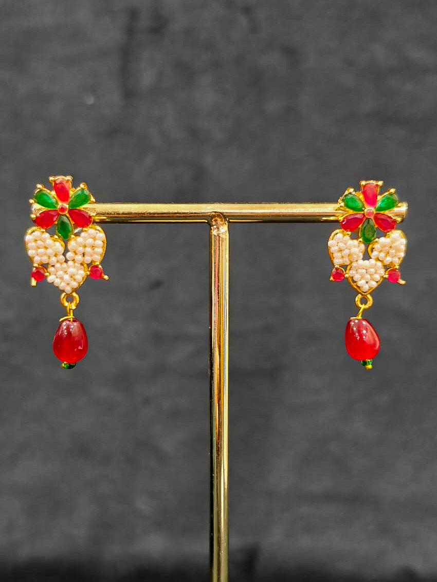 Close-up of an ornate traditional Pearl Pendant Set  earrings with Pearl and Colored Stones. Festive celebration look enhanced with traditional Pearl jewelry. Close-up of detailed enamel craftsmanship in Pearl jewelry.