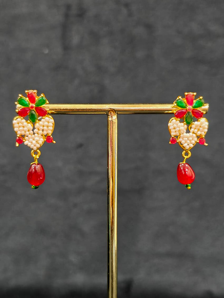 Close-up of an ornate traditional Pearl Pendant Set  earrings with Pearl and Colored Stones. Festive celebration look enhanced with traditional Pearl jewelry. Close-up of detailed enamel craftsmanship in Pearl jewelry.
