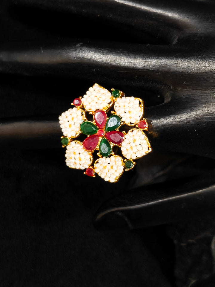 Close-up of an ornate traditional (Bright Gold Polish) Red,Green and White Collar jewellery set and earrings and Ring with Pearls and Red & Green Colored Stones. Mehendi ceremony look completed with a handcrafted Pearl jewelry set. Woman wearing a vibrant Pearl artificial jewelry set for celebrations.