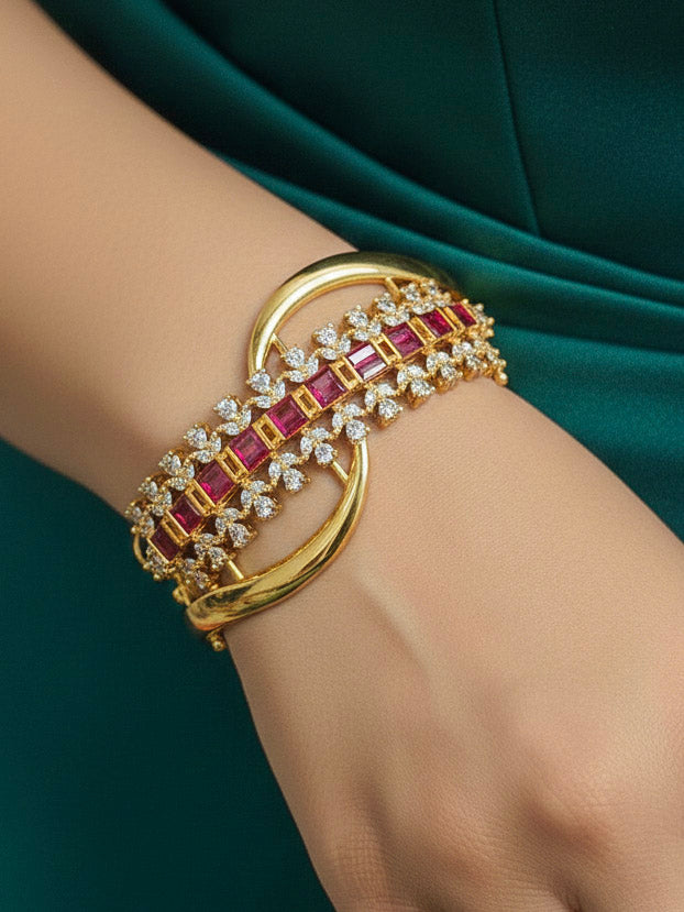 Close-up of a woman wearing an ornate Indo-western Pink (Bright gold) Diamond Bracelet with American Diamond and Colored Stones. Woman wearing a sparkling American diamond artificial bracelet for a party. Close-up of an anti-tarnish artificial American Diamond bracelet styled for wedding guests.