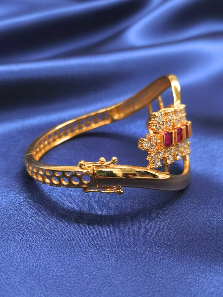 Close-up of a woman wearing an ornate Indo-western Pink (Bright gold) Diamond Bracelet with American Diamond and Colored Stones. Woman wearing a sparkling American diamond artificial bracelet for a party. Close-up of an anti-tarnish artificial American Diamond bracelet styled for wedding guests.