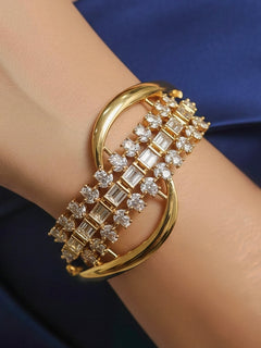 Close-up of a woman wearing an ornate Indo-western White (Bright gold) Diamond Bracelet with American Diamond and Colored Stones. Woman wearing a sparkling American diamond artificial bracelet for a party. Close-up of an anti-tarnish artificial American Diamond bracelet styled for wedding guests.