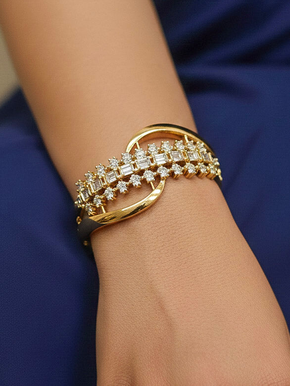 Close-up of a woman wearing an ornate Indo-western White (Bright gold) Diamond Bracelet with American Diamond and Colored Stones. Woman wearing a sparkling American diamond artificial bracelet for a party. Close-up of an anti-tarnish artificial American Diamond bracelet styled for wedding guests.