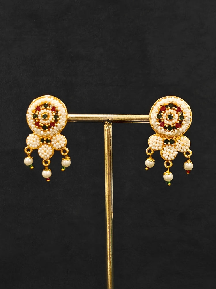 Close-up of an ornate traditional (Bright Gold Polish) Red,Green and White Choker jewellery set and earrings and Ring with Pearls and Red & Green Colored Stones. Mehendi ceremony look completed with a handcrafted Pearl jewelry set. Woman wearing a vibrant Pearl artificial jewelry set for celebrations.