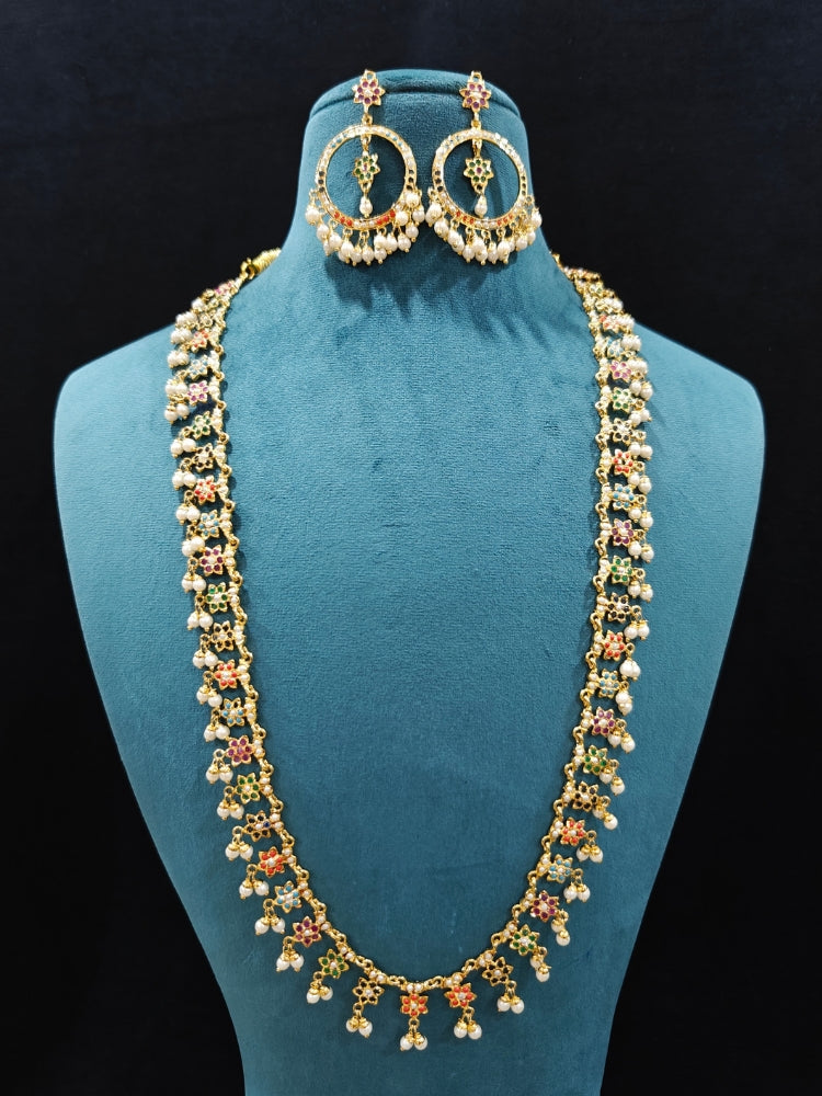 Close-up of an ornate handmade jadau jewelry set and earrings with multicolor jadau gemstones. This is a perfect long jadau jewelry set for weddings, festivals and more. Can also be worn as bridal long jadau jewelry for indian weddings. 