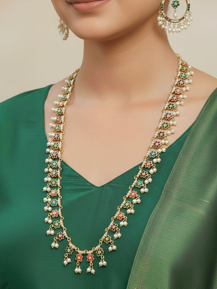 Close-up of a woman wearing an ornate handmade jadau jewelry set and earrings with multicolor jadau gemstones. This is a perfect long jadau jewelry set for weddings, festivals and more. Can also be worn as bridal long jadau jewelry for indian weddings. 