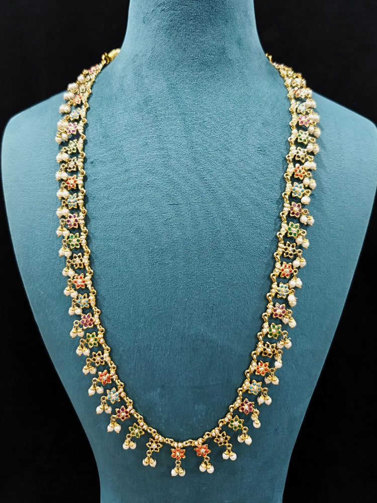 Close-up of an ornate handmade jadau jewelry set and earrings with multicolor jadau gemstones. This is a perfect long jadau jewelry set for weddings, festivals and more. Can also be worn as bridal long jadau jewelry for indian weddings. 