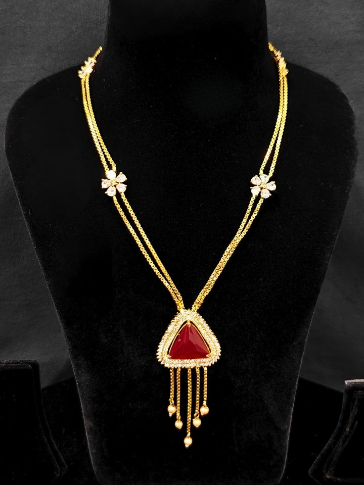 An elegant artificial diamond necklace with red colored stone and matching earrings. This premium artificial diamond jewelry set is perfect for special occasions, from Indian weddings to engagement parties, offering sophisticated glamour without the high price tag.