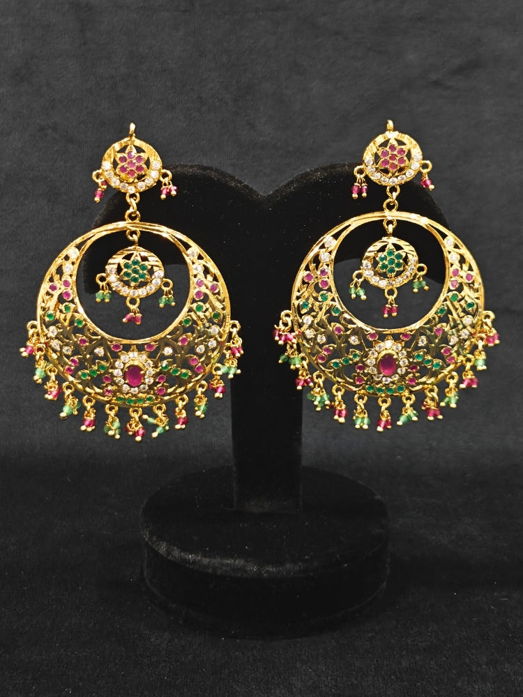 Close-up of an ornate traditional Ruby Pink and Green jadau gold earrings with Beads and Color Stone. Elegant festive wear styled with high-quality imitation Jadau earrings. Perfect Jadau Earrings set for weddings and festivals.