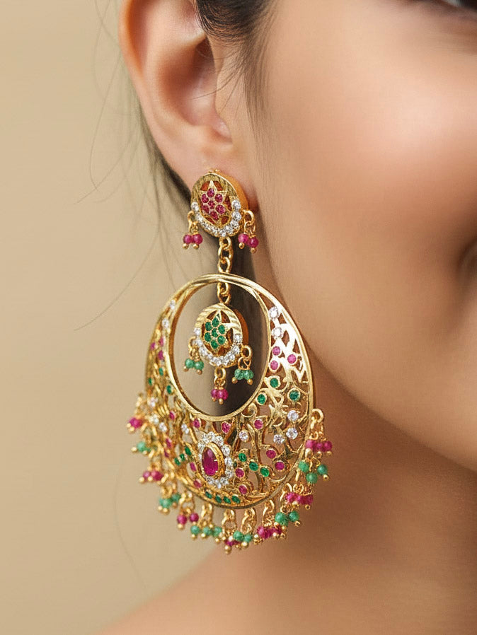 Close-up of a woman wearing an ornate traditional Ruby Pink and Green jadau gold earrings with Beads and Color Stone. Elegant festive wear styled with high-quality imitation Jadau earrings. Perfect Jadau Earrings set for weddings and festivals.