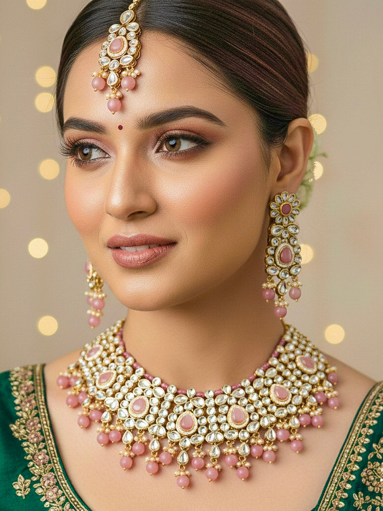 Close-up of a woman wearing an ornate traditional Pink Collar jewellery set and earrings and maangtikka with Kundan, Beads and Pearls. Royal bridal look featuring a traditional Kundan necklace set. Woman wearing trending Kundan artificial jewelry for wedding season in India. Close-up of intricate Kundan craftsmanship in artificial bridal jewelry.