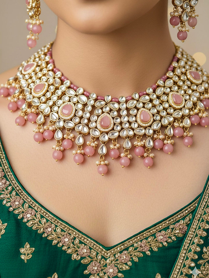Close-up of a woman wearing an ornate traditional Pink Collar jewellery set and earrings and maangtikka with Kundan, Beads and Pearls. Royal bridal look featuring a traditional Kundan necklace set. Woman wearing trending Kundan artificial jewelry for wedding season in India. Close-up of intricate Kundan craftsmanship in artificial bridal jewelry.