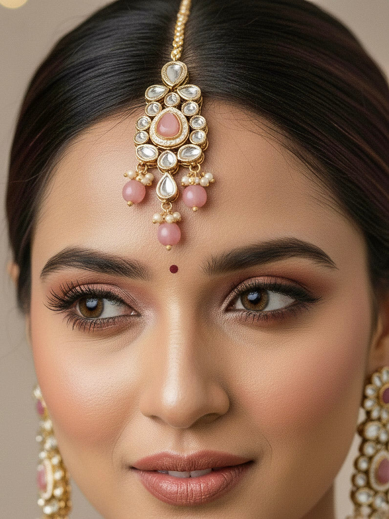Close-up of a woman wearing an ornate traditional Pink Collar jewellery set and earrings and maangtikka with Kundan, Beads and Pearls. Royal bridal look featuring a traditional Kundan necklace set. Woman wearing trending Kundan artificial jewelry for wedding season in India. Close-up of intricate Kundan craftsmanship in artificial bridal jewelry.