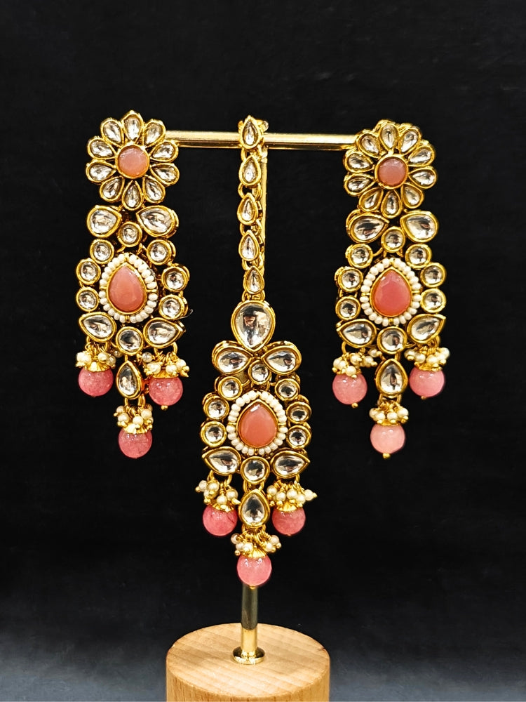 Close-up of an ornate traditional Pink Collar jewellery set and earrings and maangtikka with Kundan, Beads and Pearls. Royal bridal look featuring a traditional Kundan necklace set. A trending Kundan artificial jewelry for wedding season in India. Close-up of intricate Kundan craftsmanship in artificial bridal jewelry.