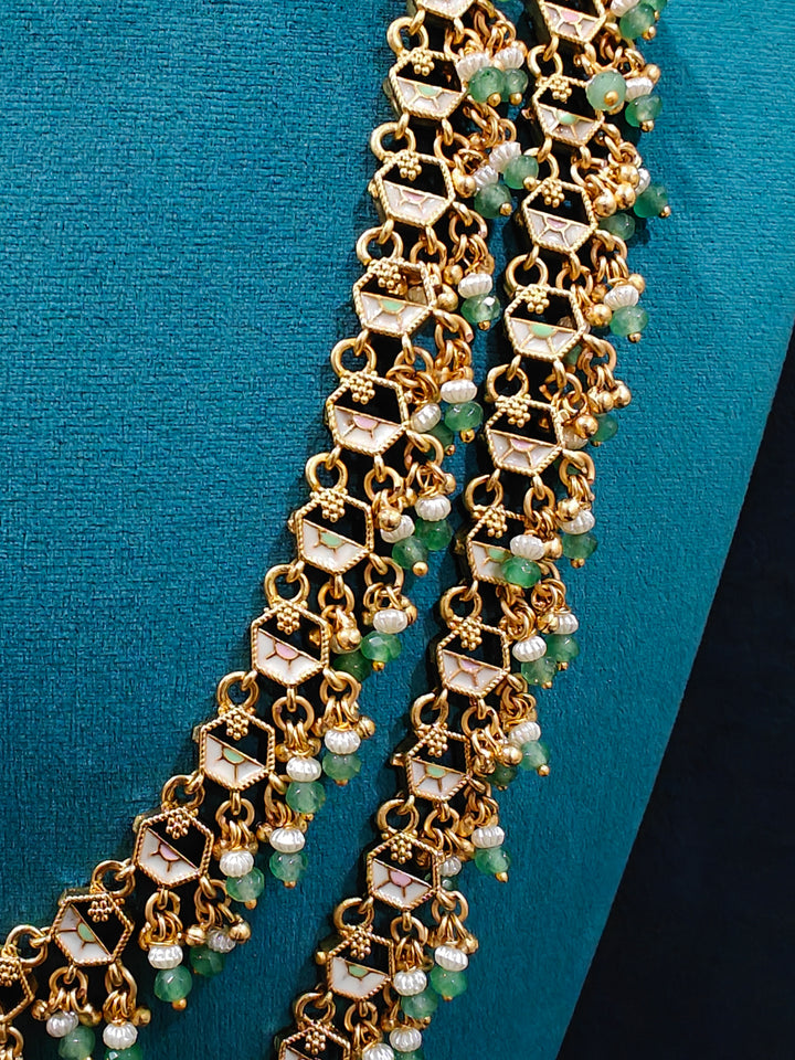 Close-up of an ornate traditional Mint Pink and Green Heritage gold Long Layered jewellery set and earrings with Colored Stones and Beads. Festive celebration outfit paired with a handcrafted heritage jewelry set. Festive  outfit styled with a royal heritage necklace. Festive celebration look enhanced with traditional Meenakari jewelry.