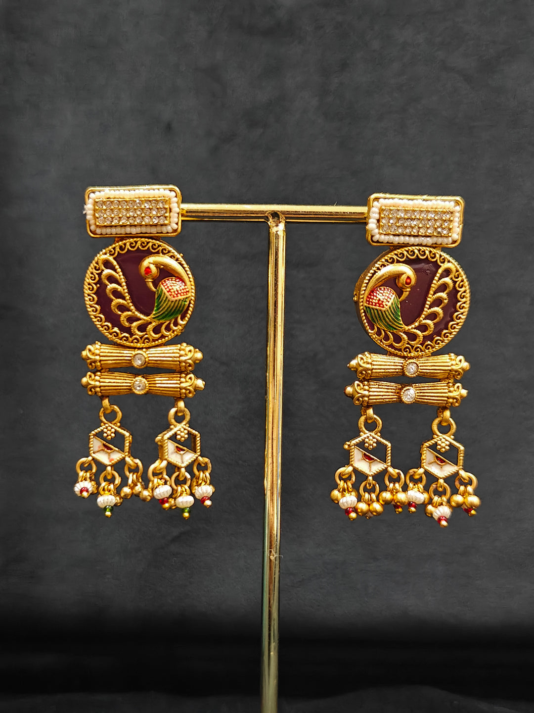 Close-up of an ornate traditional Dark Pink Heritage gold Long Layered jewellery set and earrings with Colored Stones and Beads. Festive celebration outfit paired with a handcrafted heritage jewelry set. Festive  outfit styled with a royal heritage necklace.