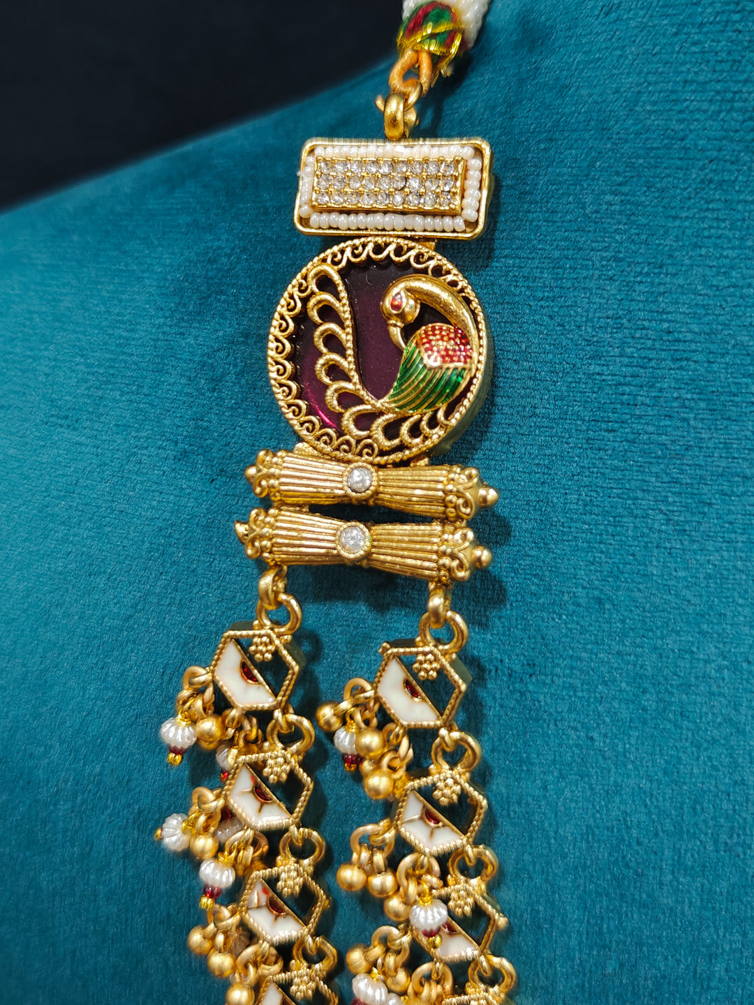 Close-up of an ornate traditional Dark Pink Heritage gold Long Layered jewellery set and earrings with Colored Stones and Beads. Festive celebration outfit paired with a handcrafted heritage jewelry set. Festive  outfit styled with a royal heritage necklace.